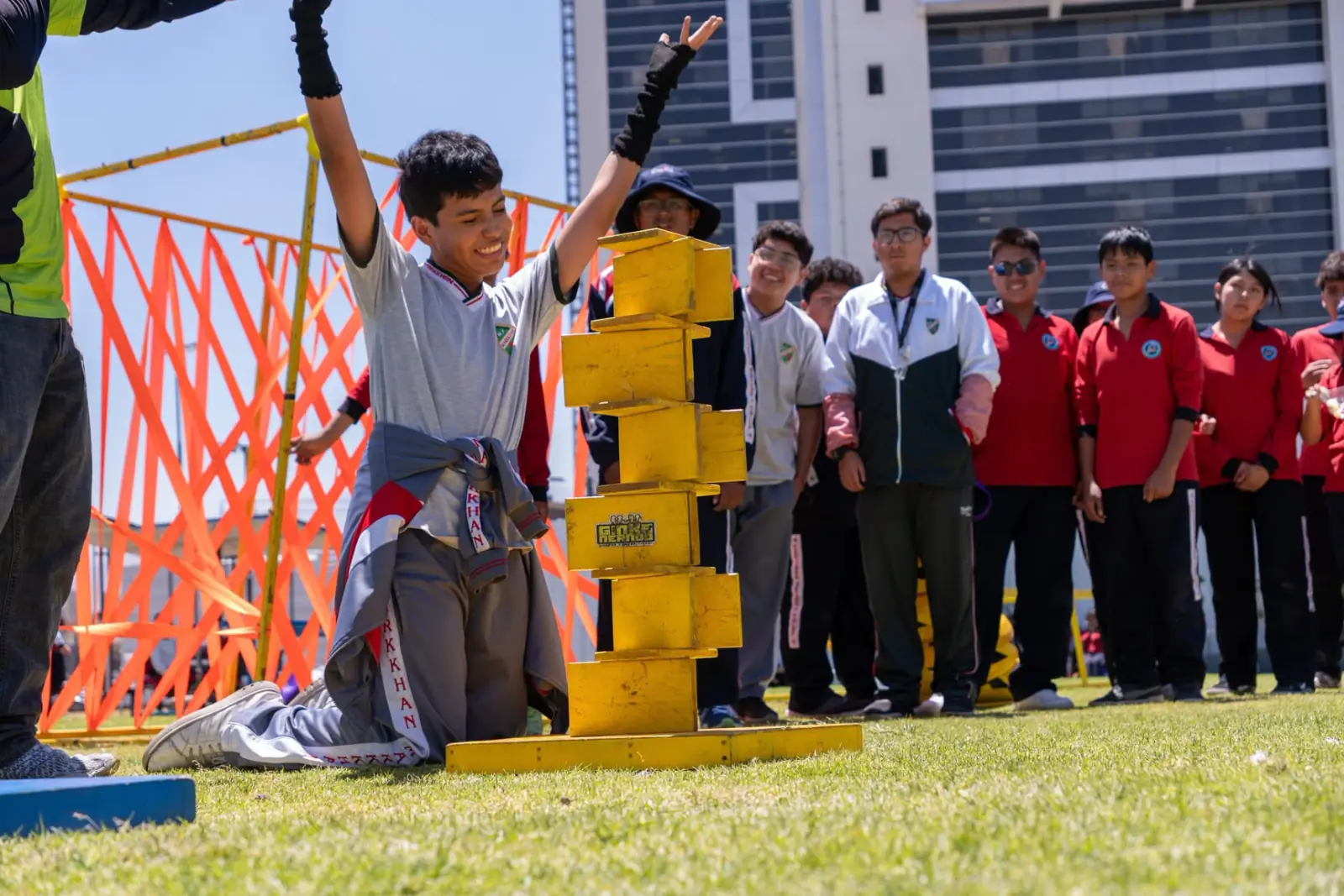 Estudiante celebrando junto a una torre de bloques