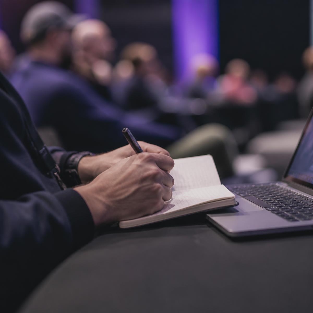 Participante tomando notas durante una charla